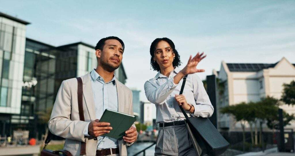 Two real estate professionals discussing future opportunities in Texas markets, symbolizing OBBB’s impact on infrastructure expansion, stacked development incentives, and workforce housing tax benefits.