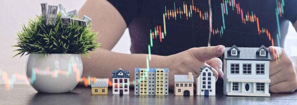 Miniature house model resting on a steady, smooth upward trend line, contrasting with a volatile stock market chart in the background.