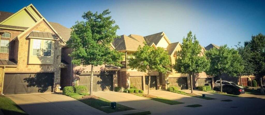 Modern suburban townhouse with an attached garage and tree-lined street in a growing Texas metro market.