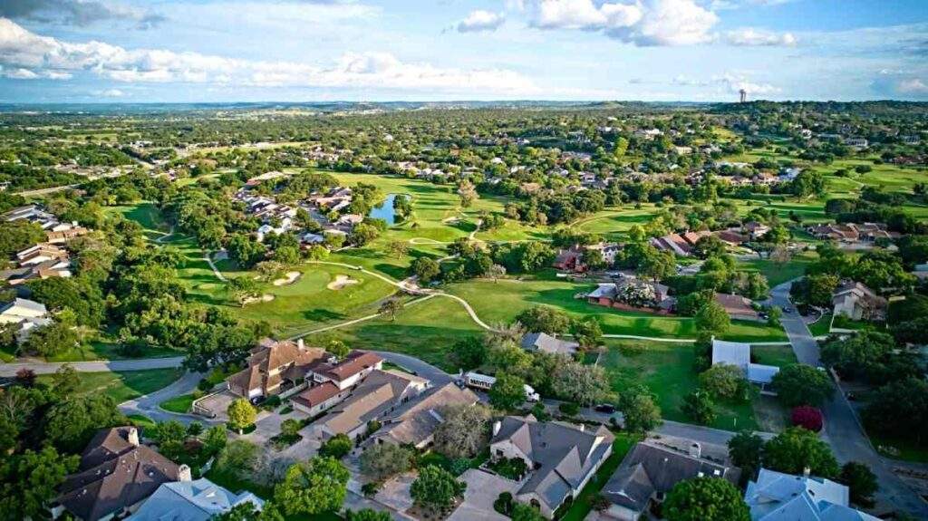 Aerial view of an established, low-risk suburban neighborhood with single-family homes, symbolizing legacy wealth.