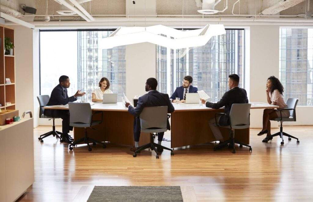 A group of professionals in a high-end office discussing residential real estate strategies.